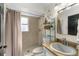 Bathroom featuring a vanity with granite countertop, a stylish mirror, and a tiled shower with curtain at 9911 Dean Cove Ln, Orlando, FL 32825