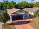 Aerial view of a charming home with a two-car garage, well-maintained landscaping, and a spacious driveway at 9911 Dean Cove Ln, Orlando, FL 32825