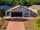 Aerial view of a charming home with a two-car garage, well-maintained landscaping, and a spacious driveway at 9911 Dean Cove Ln, Orlando, FL 32825