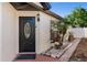 Charming front door with oval glass insert and black hardware, complemented by a well-maintained walkway and manicured landscaping at 9911 Dean Cove Ln, Orlando, FL 32825