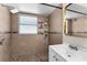 Close-up of the shower with decorative tile and convenient storage shelves for toiletries at 9911 Dean Cove Ln, Orlando, FL 32825
