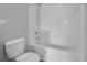 A clean bathroom featuring a toilet next to a tub with white tile at 12928 Lexington Summit St, Orlando, FL 32828