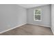 A bedroom with light gray walls, wood-look flooring, and a window at 12928 Lexington Summit St, Orlando, FL 32828