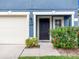 Close-up of the front door featuring black door with adjacent garage at 12928 Lexington Summit St, Orlando, FL 32828