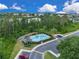Aerial view of the community pool surrounded by trees and lounge chairs at 12928 Lexington Summit St, Orlando, FL 32828