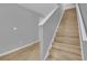 Staircase with hardwood steps and white banister, leading to the upper level of the home at 12928 Lexington Summit St, Orlando, FL 32828