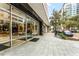 Building entrance with modern glass doors, sleek black accents, and landscaped sidewalk at 101 S Eola Dr # 812, Orlando, FL 32801