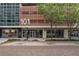 Modern building exterior with large windows and prominent address signage, lush trees, and brick-paved street at 101 S Eola Dr # 812, Orlando, FL 32801