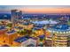 Spectacular twilight aerial view of a city skyline, with buildings illuminated and reflected in a lake at 101 S Eola Dr # 812, Orlando, FL 32801