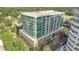 Modern high-rise condo building with walls of windows and balconies, surrounded by lush greenery and palm trees at 101 S Eola Dr # 812, Orlando, FL 32801