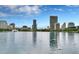 Scenic view of a lake with swans, lush greenery, and a vibrant city skyline in the background at 101 S Eola Dr # 812, Orlando, FL 32801
