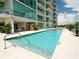 A long, rectangular in-ground pool on the side of a condo building featuring lounge chairs at 101 S Eola Dr # 812, Orlando, FL 32801