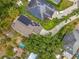 Aerial view of homes with solar panels, lush landscaping, and a long driveway at 10105 Dean Point Pl, Orlando, FL 32825