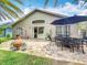 Paver patio with an outdoor dining set, a fire pit, and lush landscaping for outdoor entertaining at 10105 Dean Point Pl, Orlando, FL 32825