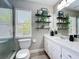 Bright bathroom with white vanity and white sink and a toilet with black decorations at 10105 Dean Point Pl, Orlando, FL 32825