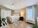 Cozy bedroom featuring a plush bed, soft lighting, and neutral tones with wood-look tile flooring at 10105 Dean Point Pl, Orlando, FL 32825