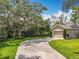 Long driveway leads to a home with solar panels, surrounded by mature trees and greenery at 10105 Dean Point Pl, Orlando, FL 32825