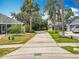Long driveway flanked by palm trees, leading to a home with a two-car garage at 10105 Dean Point Pl, Orlando, FL 32825