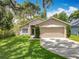 Well-maintained single-story home with a two-car garage and lush green lawn at 10105 Dean Point Pl, Orlando, FL 32825