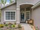 Inviting front porch with decorative windows, a cozy bench, and beautiful landscaping at 10105 Dean Point Pl, Orlando, FL 32825