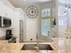 Bright kitchen with stainless steel appliances, white cabinetry, granite countertops, and a large decorative wall clock at 10105 Dean Point Pl, Orlando, FL 32825