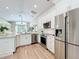 Bright, updated kitchen with stainless steel appliances, sleek white cabinetry, wood-style flooring, and granite countertops at 10105 Dean Point Pl, Orlando, FL 32825