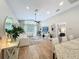 A well-lit living room with wood floors, white furniture, a large window, and an adjacent dining area at 10105 Dean Point Pl, Orlando, FL 32825