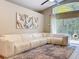 Spacious living room with a large white sectional sofa, modern art, and access to the outdoor patio at 10105 Dean Point Pl, Orlando, FL 32825