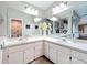 Bright main bathroom featuring double sinks, bright lighting, decorative vases, and an ornate mirror at 10105 Dean Point Pl, Orlando, FL 32825