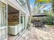Charming outdoor patio with brick pavers, dining set, lush landscaping, and sliding glass doors to the living room at 10105 Dean Point Pl, Orlando, FL 32825