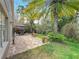 Backyard brick patio area with outdoor dining, lush tropical plants, and palm trees creating a private oasis at 10105 Dean Point Pl, Orlando, FL 32825