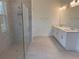 Elegant bathroom featuring double vanities, tiled floors and a modern glass-enclosed shower at 1016 Gloryland Ct, Sanford, FL 32771