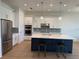 Modern kitchen boasts white cabinets, stainless appliances, a large island, and stylish pendant lighting at 1016 Gloryland Ct, Sanford, FL 32771