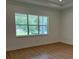 A bright bedroom featuring wood flooring, and a large window at 1059 Gloryland Ct, Sanford, FL 32771