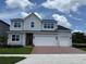 Two-story home showcasing a three-car garage, a red brick driveway, and a neatly manicured lawn at 1059 Gloryland Ct, Sanford, FL 32771