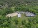 Overhead shows a horse complex, with a stable, white fencing, parking, a ring and boats, surrounded by dense forest at 111 Crown Oaks Way # 101, Longwood, FL 32779
