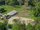 Aerial view of horse property featuring a large barn, riding arena, and fenced paddocks at 111 Crown Oaks Way # 101, Longwood, FL 32779