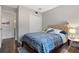 This is a bedroom with a blue patterned bed and upholstered headboard, next to a simple white nightstand at 111 Crown Oaks Way # 101, Longwood, FL 32779