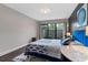 Comfortable bedroom featuring a blue bed with stylish decor, sliding glass doors, and ample natural light at 111 Crown Oaks Way # 101, Longwood, FL 32779