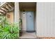 Welcoming entrance with a blue door, lush plants, and natural light creating a warm and inviting ambiance at 111 Crown Oaks Way # 101, Longwood, FL 32779