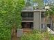Two-story home featuring a balcony, a brick patio, and lush greenery at 111 Crown Oaks Way # 101, Longwood, FL 32779