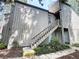 Two-story townhouse exterior with wooden stairs leading to the entrance and mature landscaping around the foundation at 111 Crown Oaks Way # 101, Longwood, FL 32779