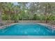 A sparkling pool surrounded by a wooden fence and lush greenery, perfect for relaxing and enjoying the outdoors at 111 Crown Oaks Way # 101, Longwood, FL 32779
