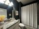 Stylish bathroom with dark walls, granite countertop vanity, and a shower-tub combo at 11456 Short Story St, Orlando, FL 32832