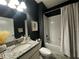 Contemporary bathroom featuring dark walls, a granite vanity, and a shower-tub with shower curtain at 11456 Short Story St, Orlando, FL 32832