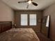Bedroom with neutral walls, carpet, ceiling fan, and a wood frame bed with two windows at 11456 Short Story St, Orlando, FL 32832