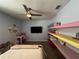 Bedroom featuring a bed, desk, shelves, and TV creating a functional and comfortable space at 11456 Short Story St, Orlando, FL 32832