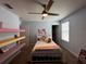 Bedroom with a bed, shelves, and a ceiling fan offers space for sleep and relaxation at 11456 Short Story St, Orlando, FL 32832