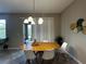 Bright dining area featuring a wood table, modern chandelier, and sliding glass doors to the outdoor space at 11456 Short Story St, Orlando, FL 32832
