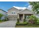 Charming two-story home with a well-manicured lawn and a two-car garage on a beautiful sunny day at 11456 Short Story St, Orlando, FL 32832